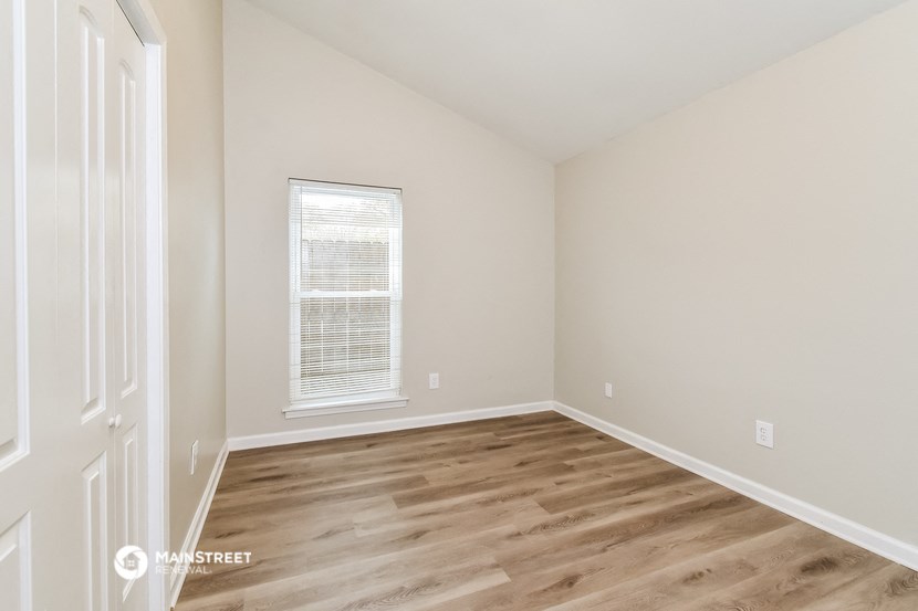 an empty room with wooden floors and a window