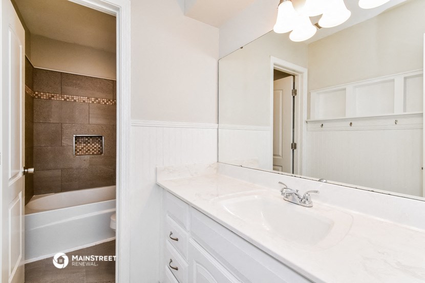 a bathroom with a sink and a shower and a mirror
