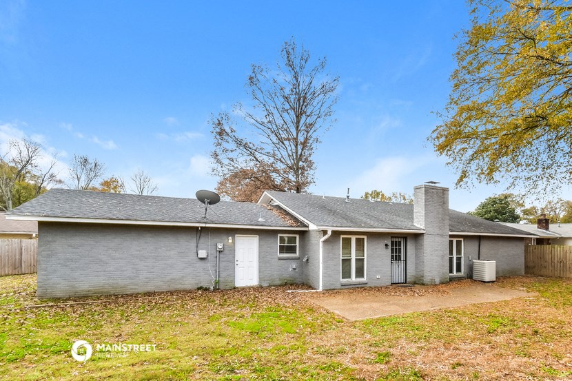 a gray house with a yard and a tree