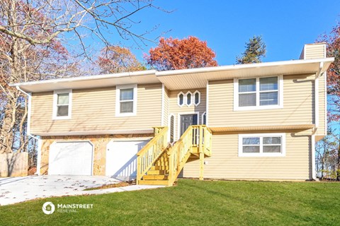 a yellow house with a yellow staircase in front of a yard