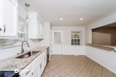 a kitchen with white cabinets and a sink and a counter top