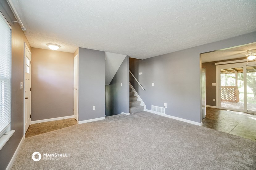 an empty living room with a staircase in a house