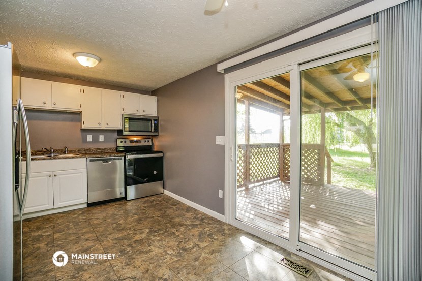 a kitchen with a sliding glass door leading to a balcony