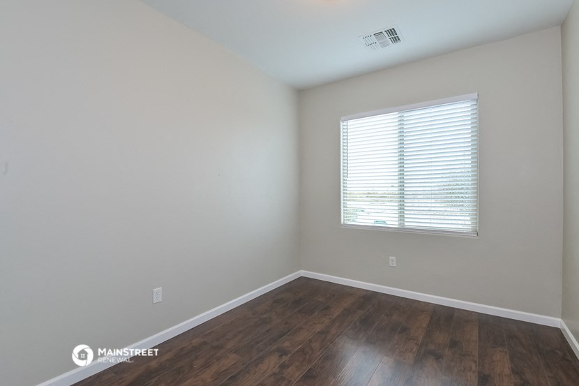 a bedroom with wood flooring and a window