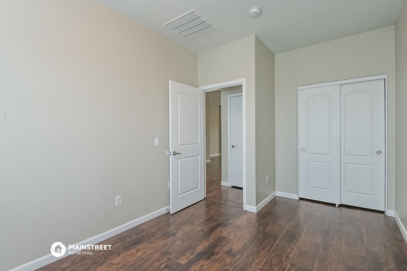 a bedroom with two doors and a door to a hallway with a door closet and