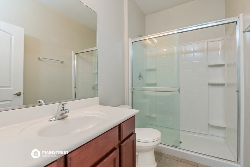 a bathroom with a shower sink and toilet and a mirror