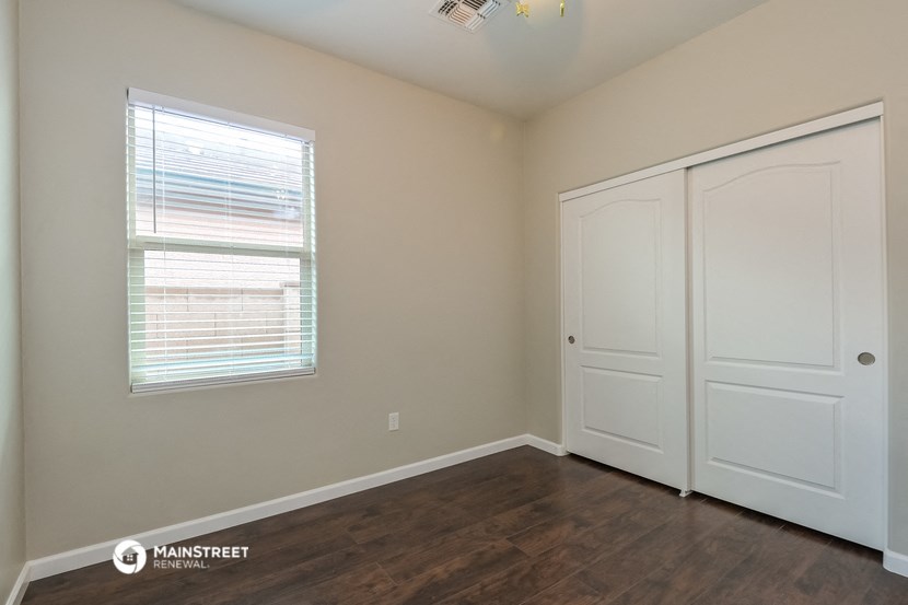 the interior of a bedroom with two doors and a window