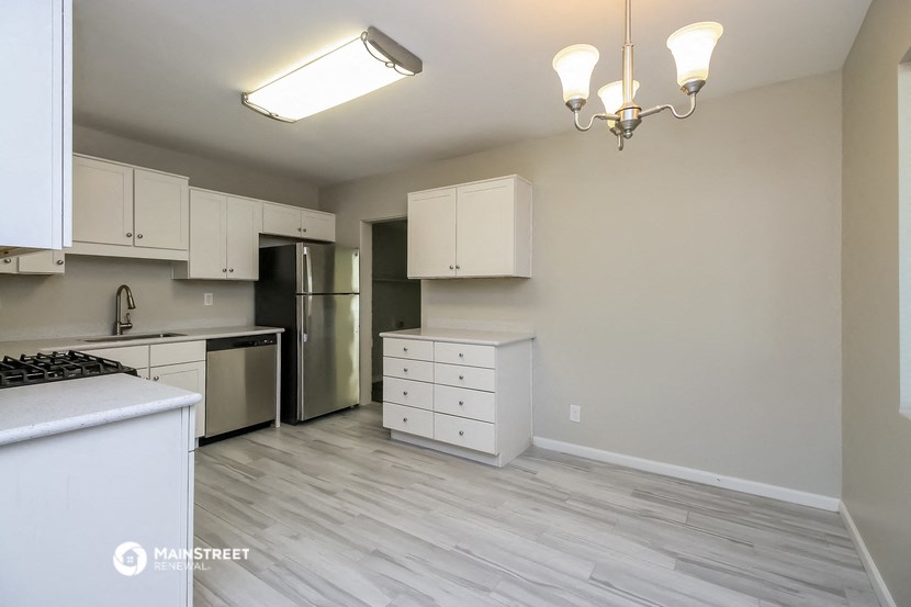 the spacious kitchen with stainless steel appliances and white cabinets