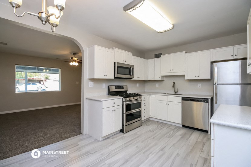 an empty kitchen with white cabinets and stainless steel appliances