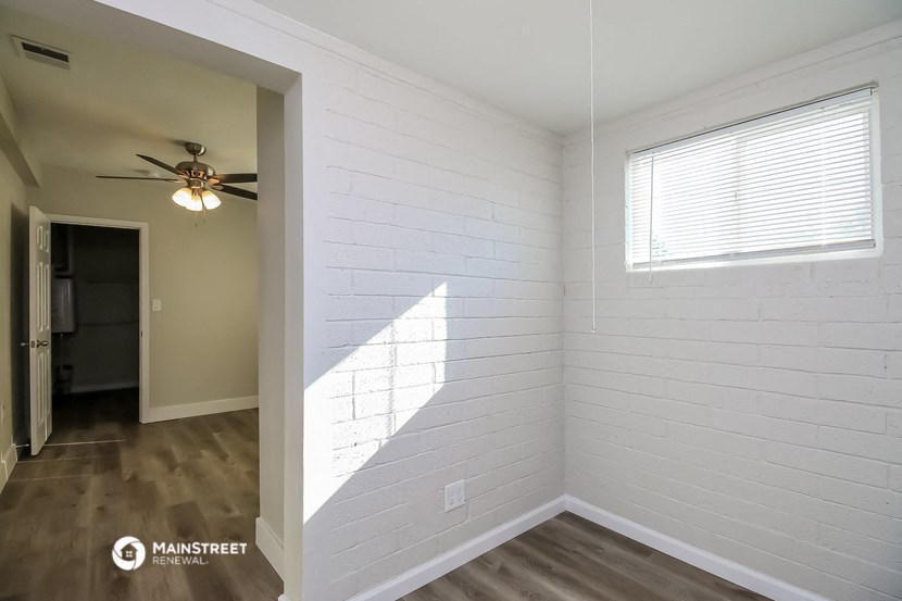 the interior of a bedroom with white walls and a ceiling fan
