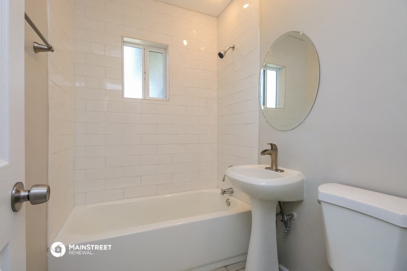 a white bathroom with a sink and a bath tub