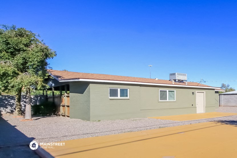 a green house with a road in front of it