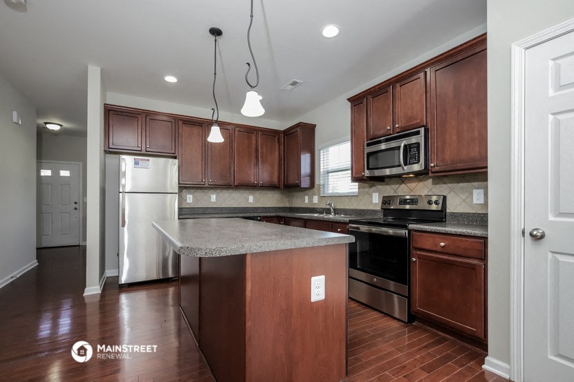 a kitchen with wooden cabinets and stainless steel appliances