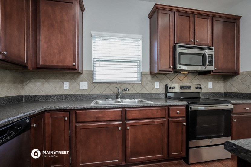 a kitchen with wooden cabinets and a sink and a microwave
