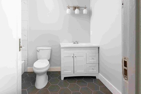 a white bathroom with a toilet and a sink