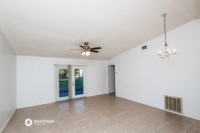 a living room with a ceiling fan and a door to a pool