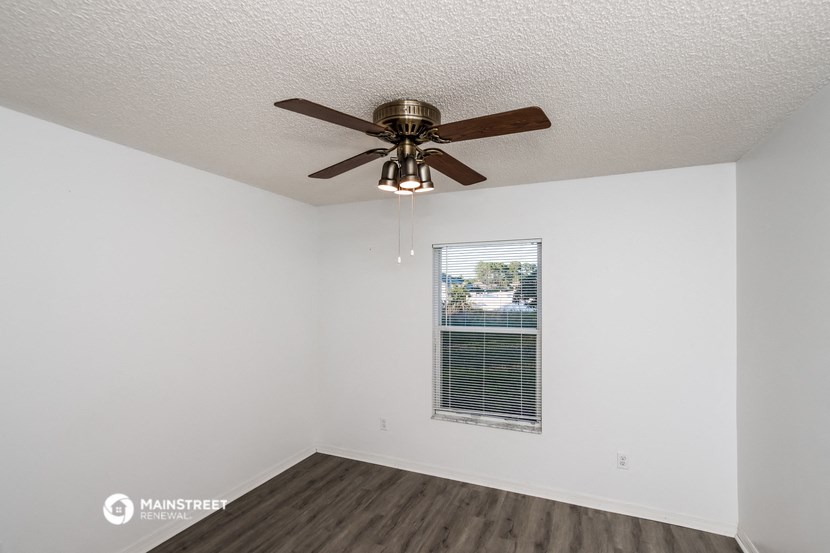 a living room with a ceiling fan and a window