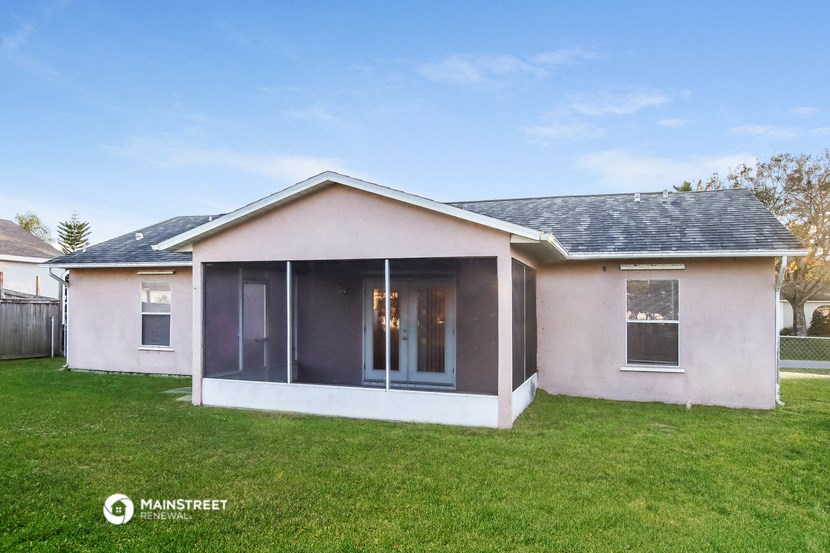 the front of a house with a lawn and a glass door