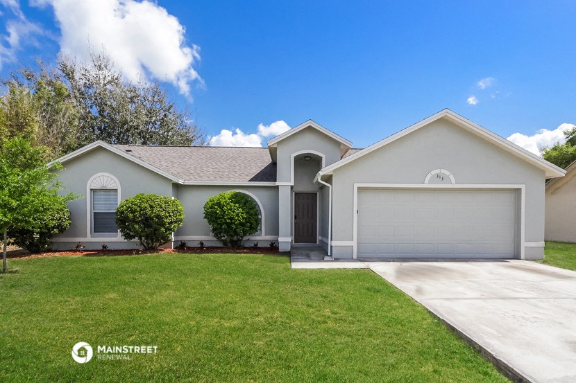 a white house with a lawn and a driveway