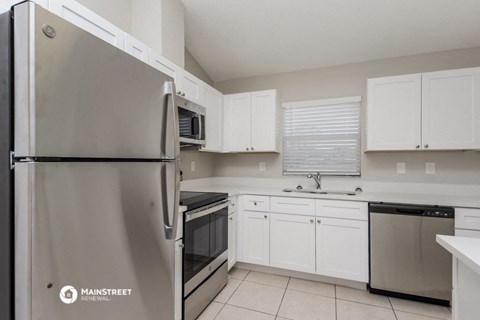 a kitchen with stainless steel appliances and white cabinets