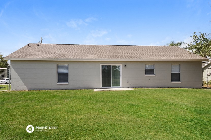 a small white house with a lawn in front of it