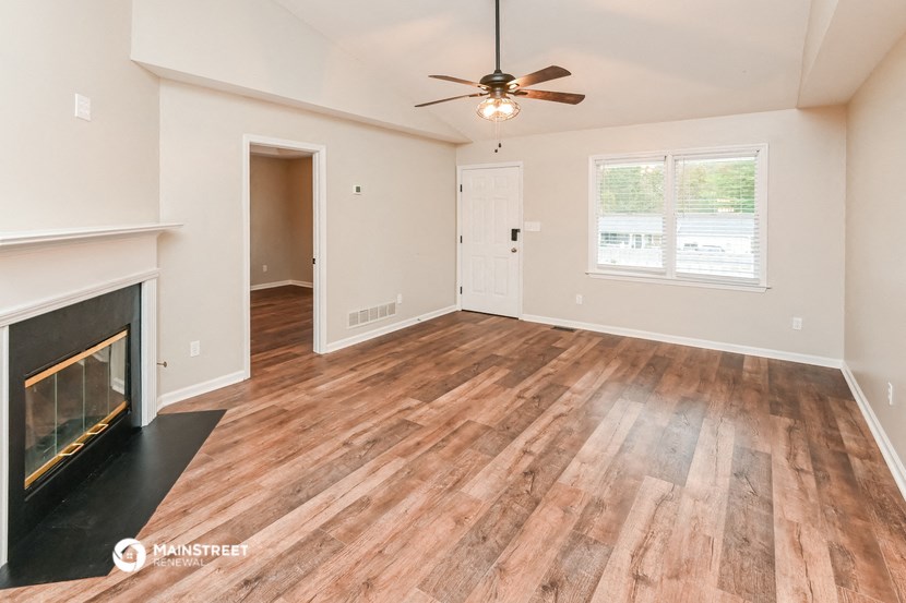 a living room with a fireplace and a ceiling fan