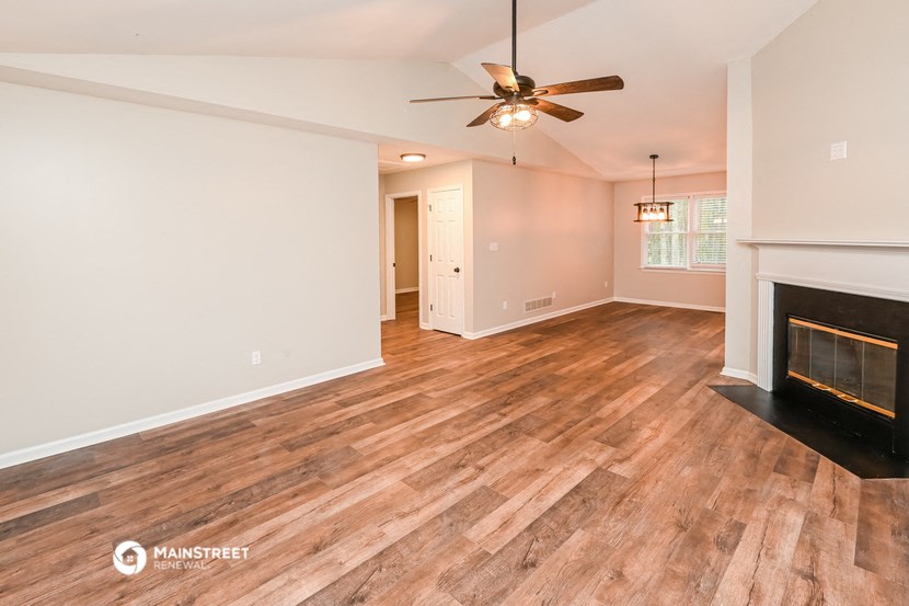 the living room with fireplace and wood flooring and a ceiling fan