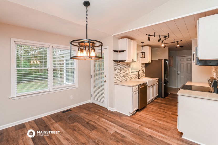 a kitchen with a large window and a kitchen island with a sink and a refrigerator