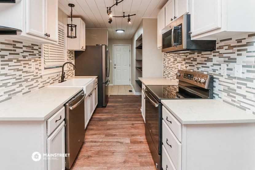 a kitchen with white cabinets and stainless steel appliances