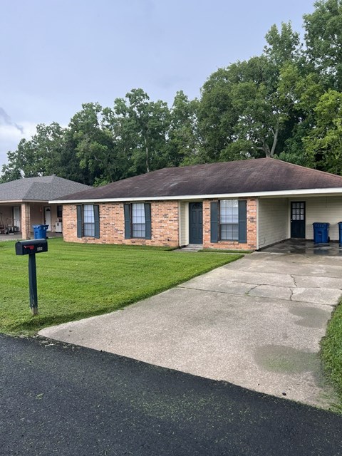 A small brick house with a blue mailbox on the left.