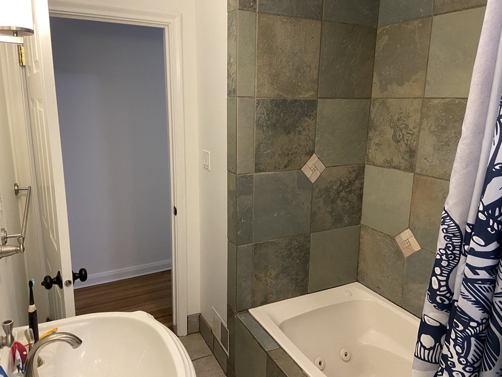 a small bathroom with a tub and a sink