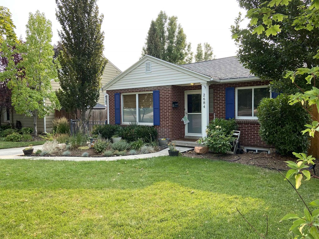 a house with a lawn and garden in front of it