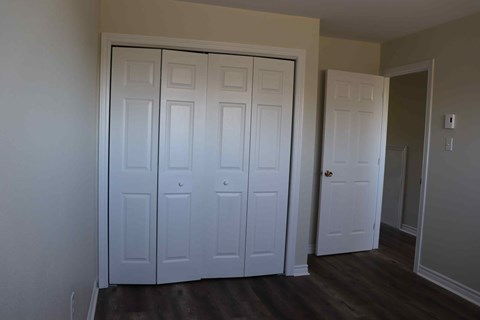a bedroom with two closets and a door to a hallway
