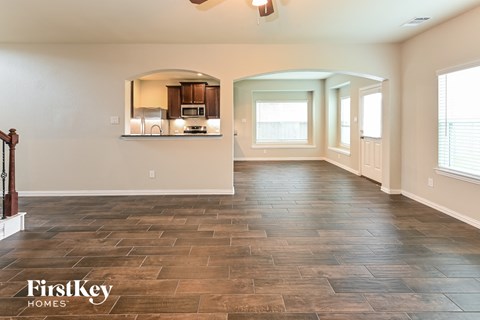 the living room and kitchen of a new home with a tile floor