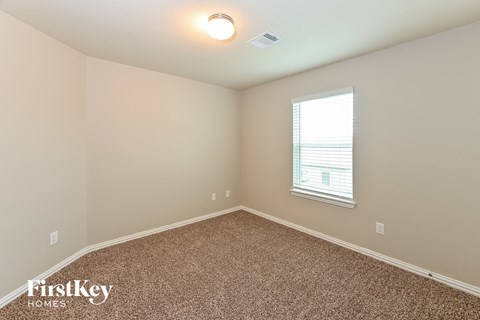 the upstairs bedroom has carpet and a window