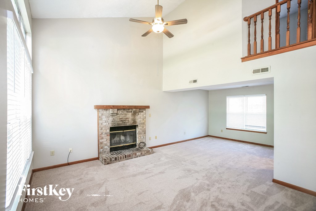 a living room with a fireplace and a ceiling fan