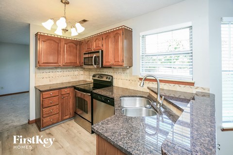a kitchen with wooden cabinets and granite counter tops and a sink