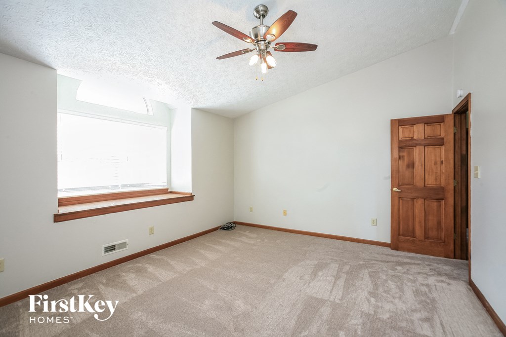 the master bedroom is spacious and has a ceiling fan