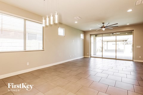 A spacious room with a fan and a sliding glass door.