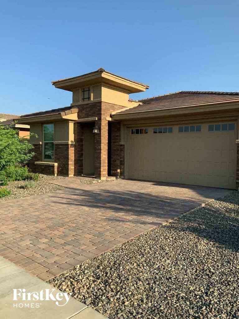 A house with a garage and a driveway in front of it.