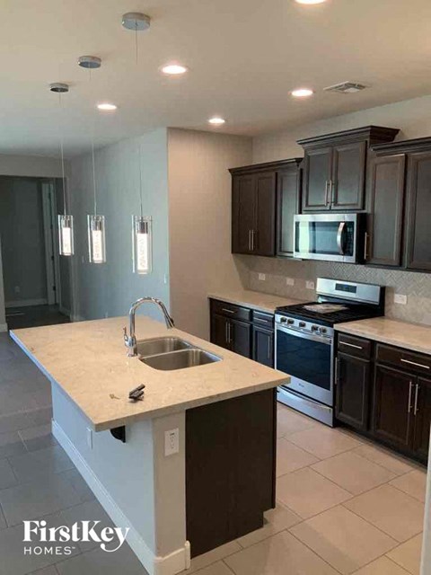 A kitchen with a sink and a microwave.