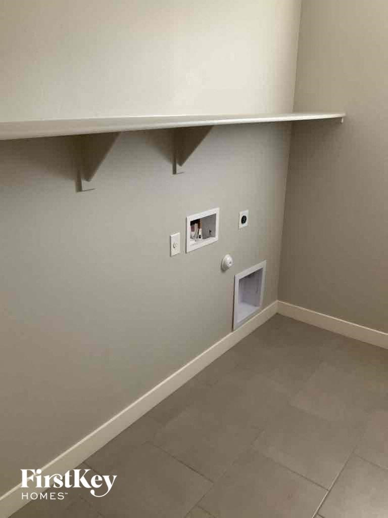 A wall with a vent and a light switch.