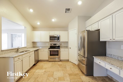 a kitchen with white cabinets and stainless steel appliances