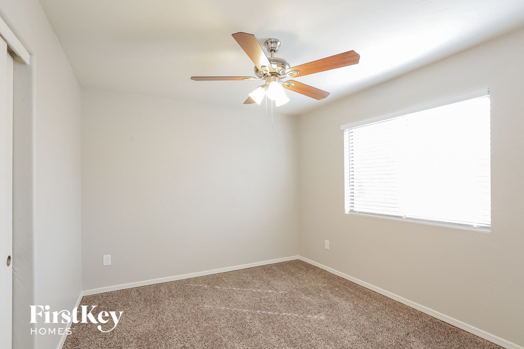 a bedroom with a ceiling fan and a window