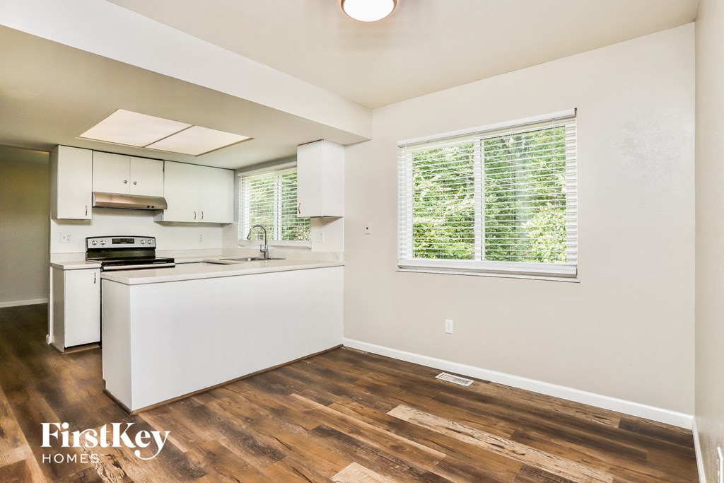 a white kitchen with white appliances and a window
