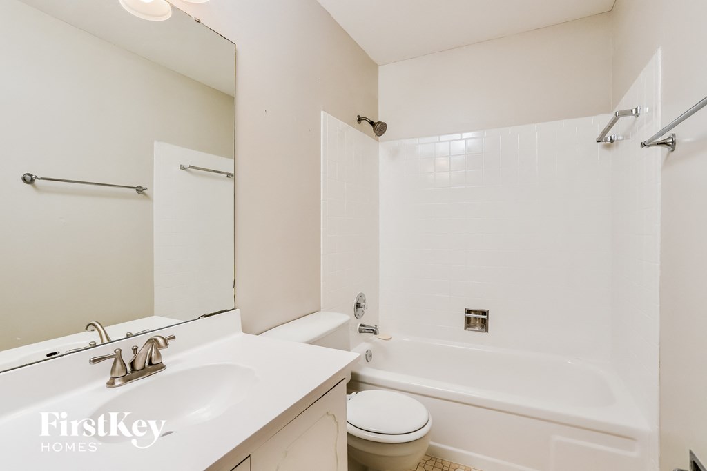 a white bathroom with a tub and a sink and a toilet