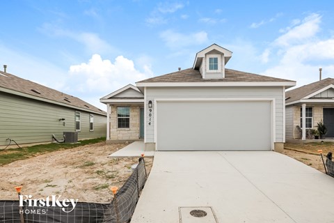 the view of the front of a house with a concrete driveway
