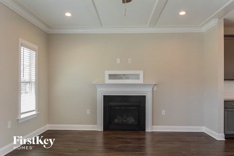 A living room with a fireplace and wooden floors.