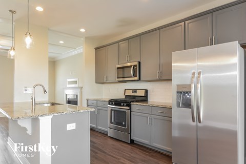 A modern kitchen with a stainless steel refrigerator and a microwave above the stove.