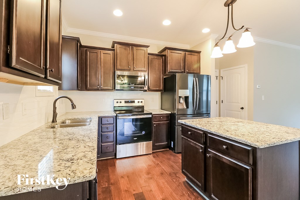 a kitchen with wooden cabinets and granite counter tops and black appliances
